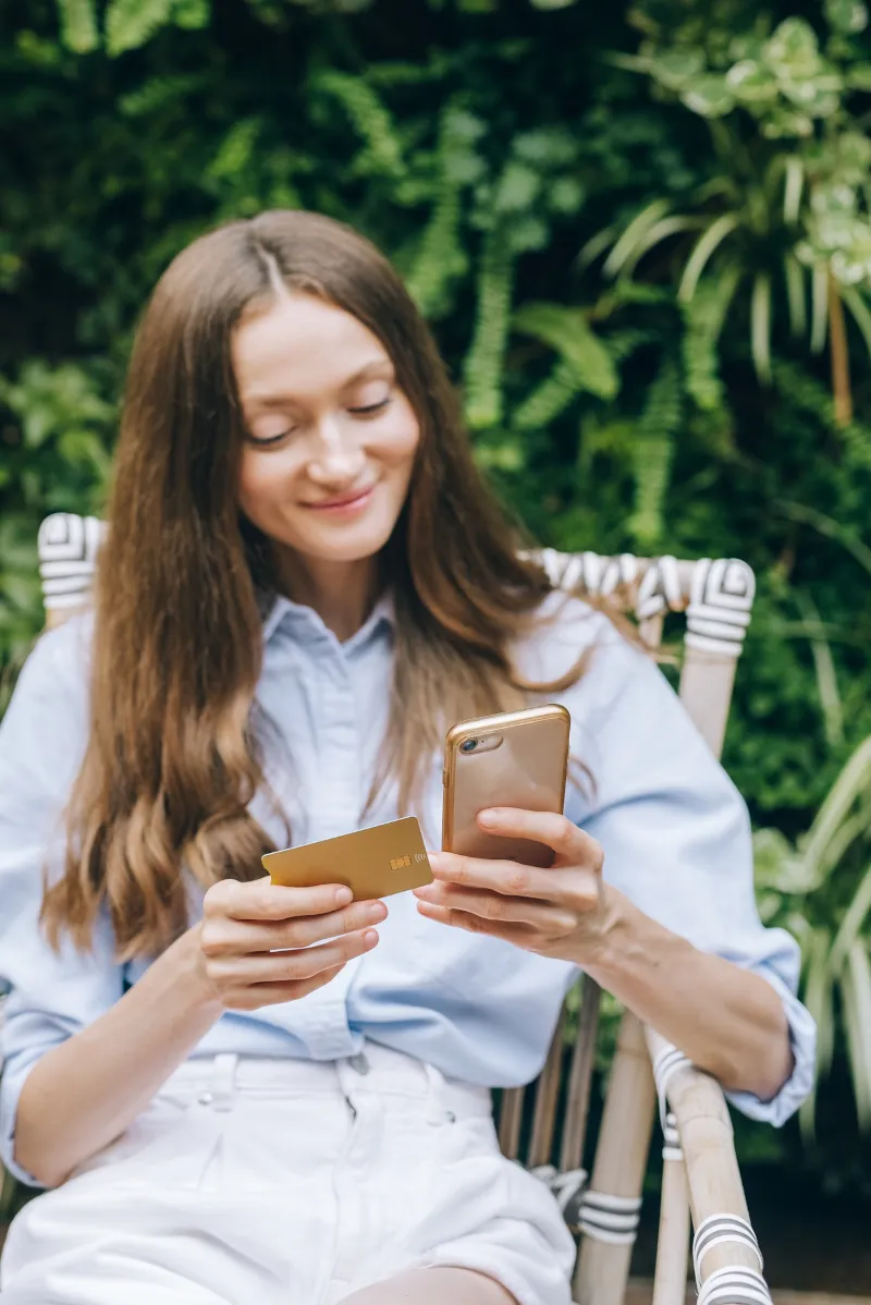 Woman using her card to pay on her phone.